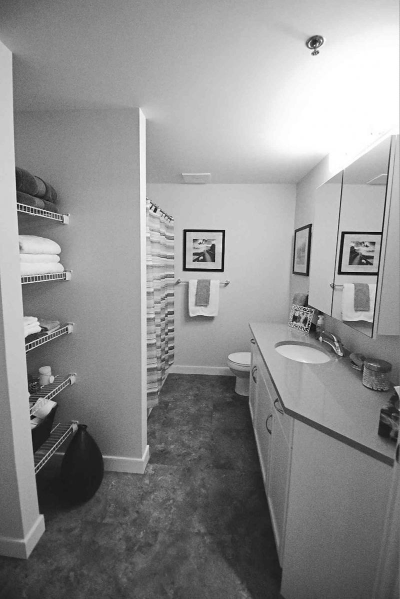 The main bath features a faux cork vinyl floor, handy linen nook, quartz and maple vanity and soaker tub and shower combo.
