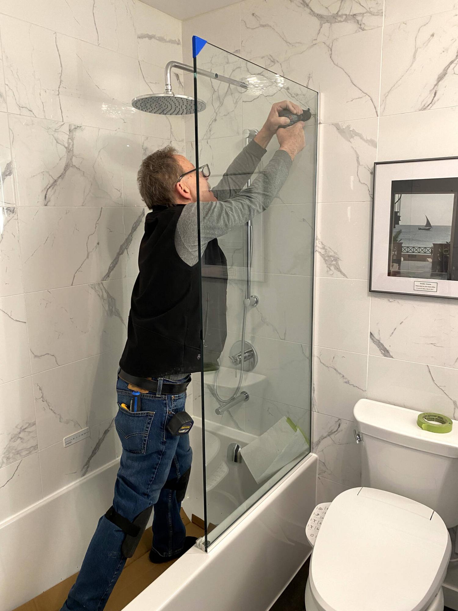  <p>Dale Gallant from SHODOR shows his prowess and expertise while mounting a glass panel for the custom shower enclosure.</p> 