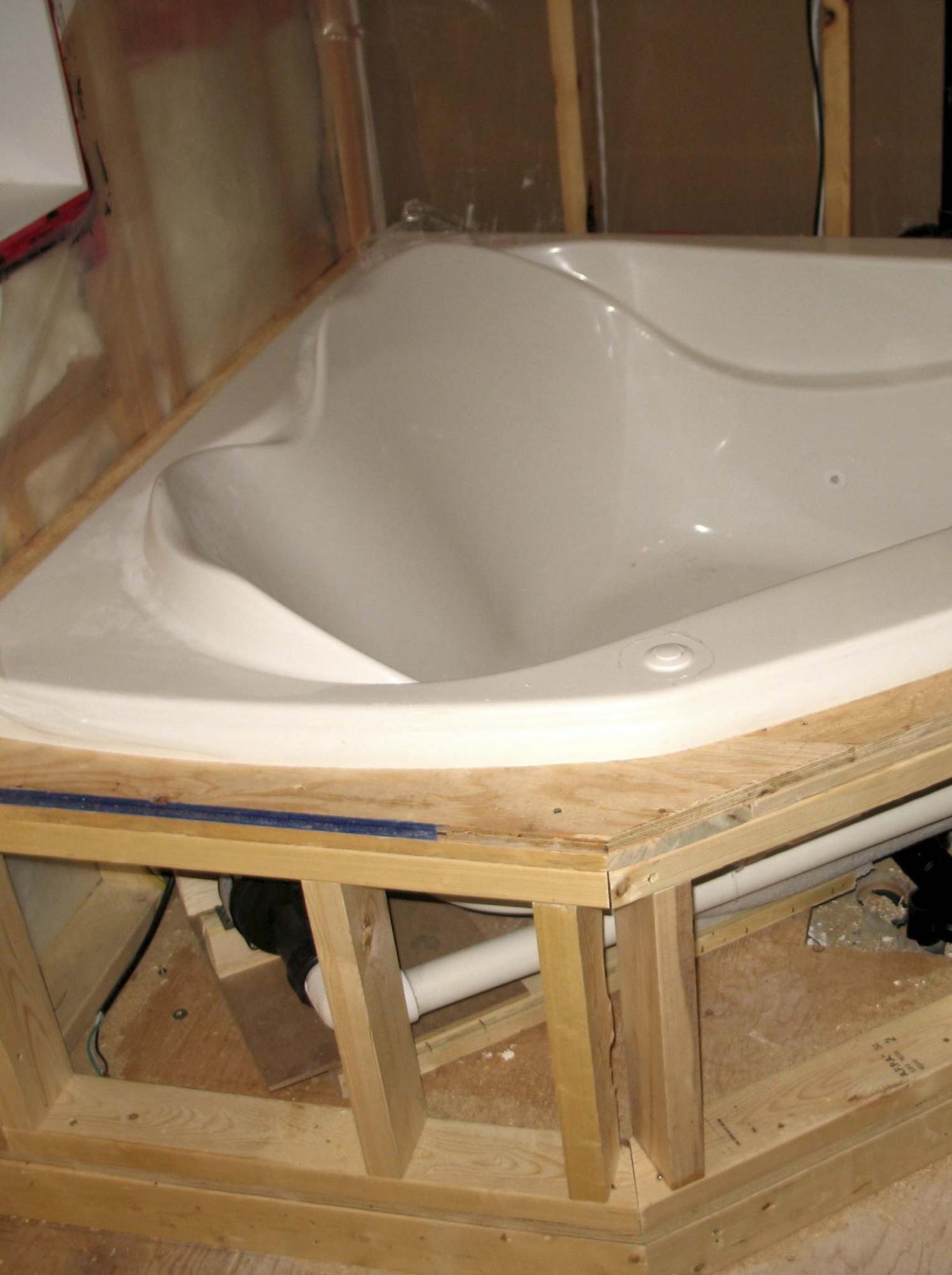 <p>The jet-pump for the tub is located underneath it near the front, so a hidden access hatch had to be made. </p>