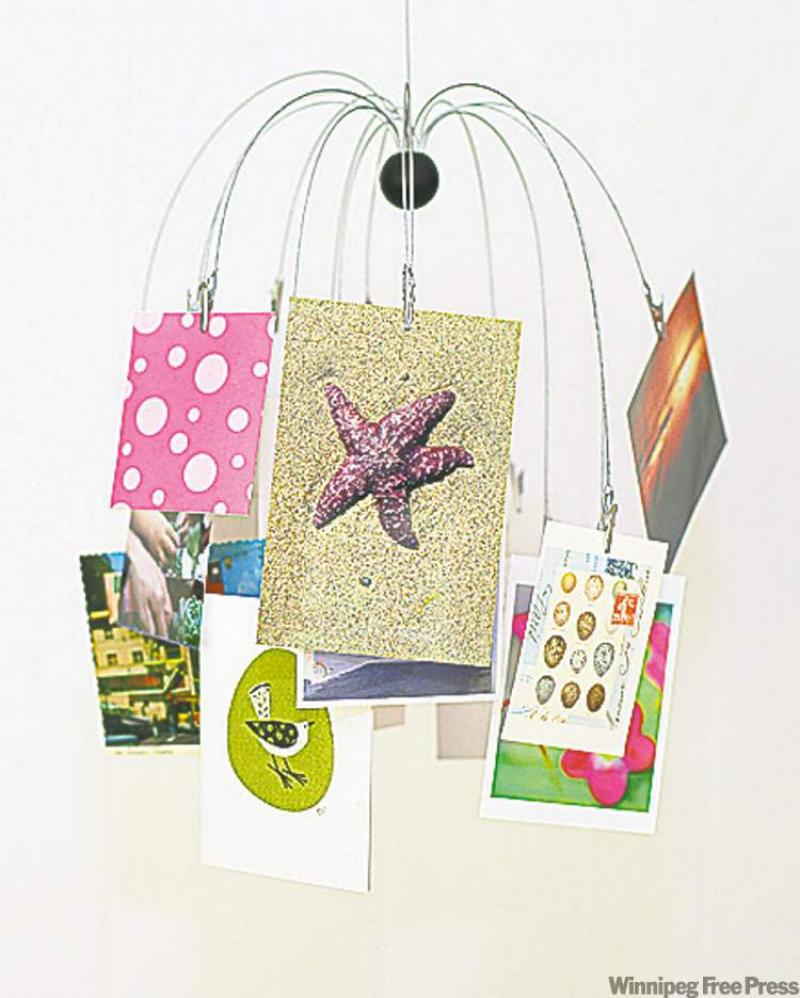 A mobile with postcards and photographs attached.
