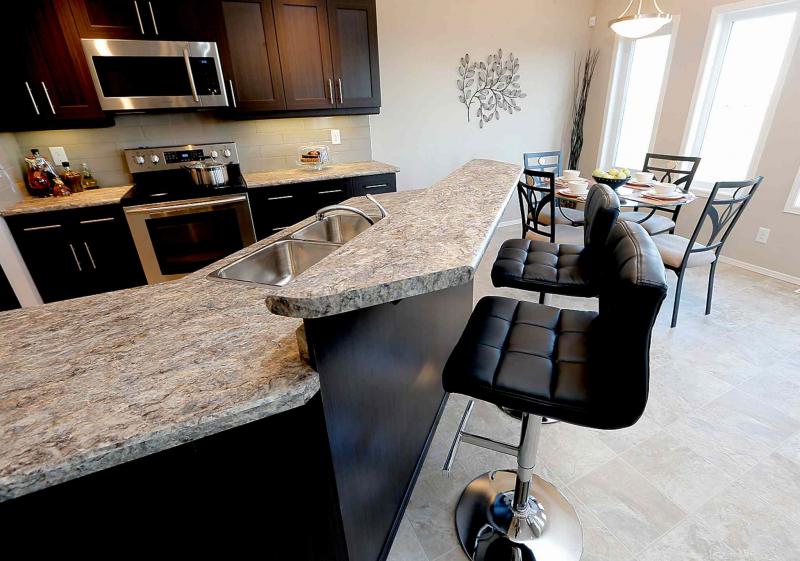 A large angled island with a raised eating bar serves as a fabulous eating area.