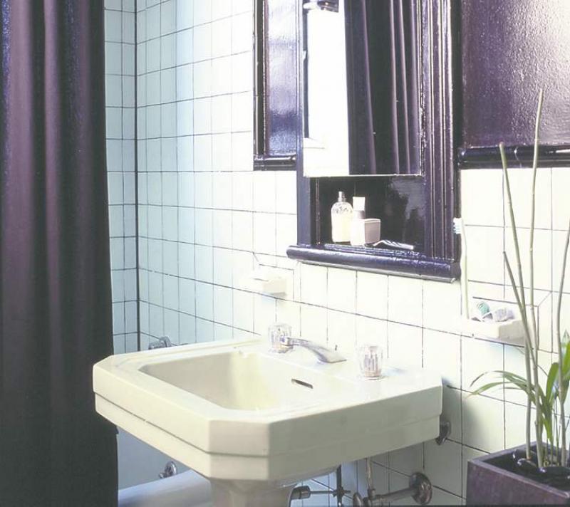 Glossy black walls give a dramatic uplift to a dated bathroom.