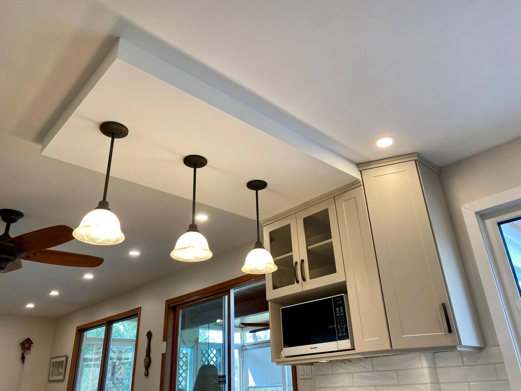  <p>The decorative bulkhead showcases three dangler lights, and merges into the upper cupboard design that conceals a plumbing stack.</p> 