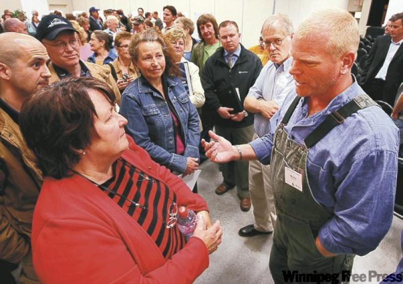 Mike Holmes speaks to residents in Okotoks, Alto. about a housing development he's planning to build. Holmes promises the homes will be built to 'maximum code' and be as energy-efficient as they are w