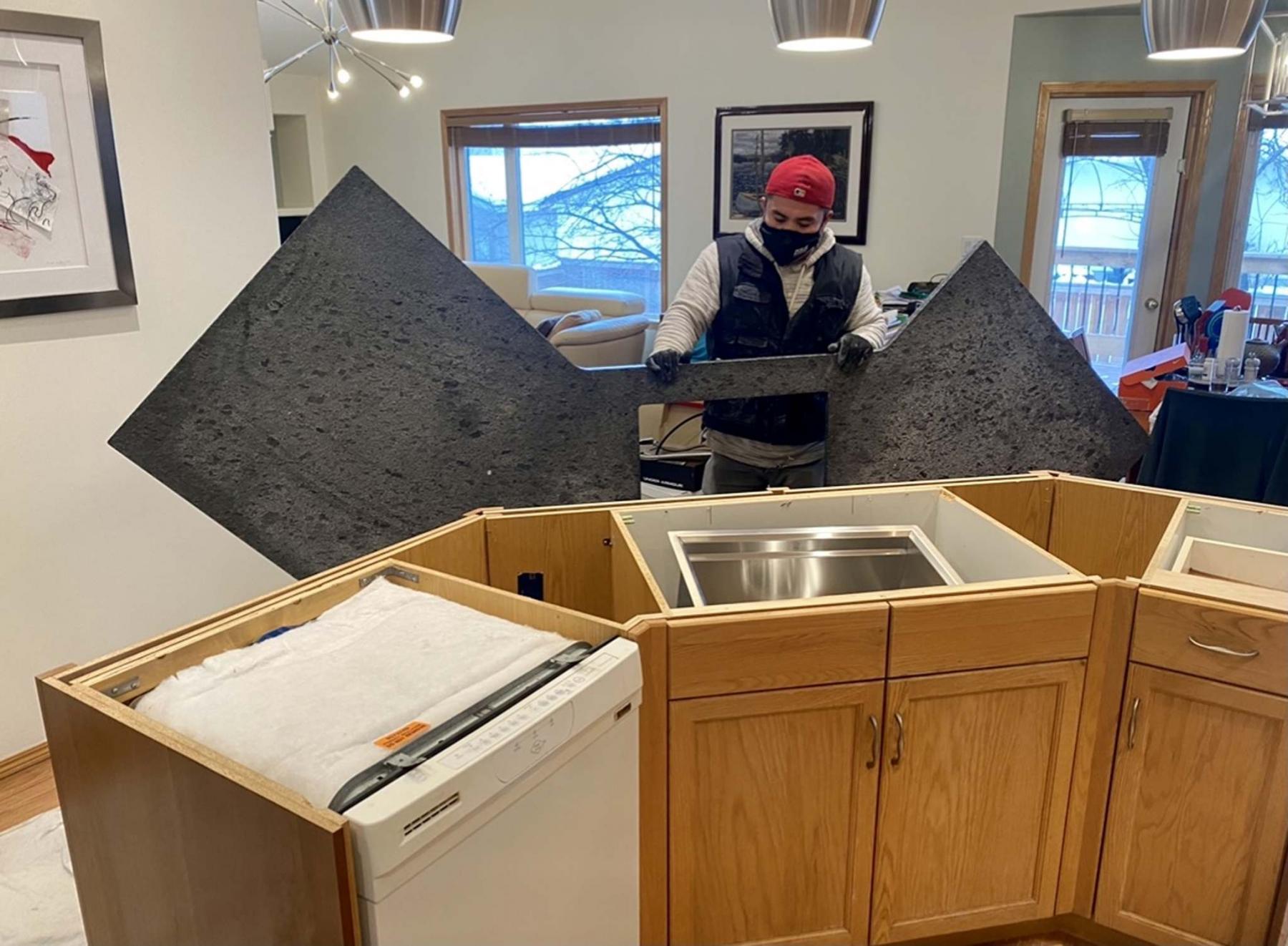 After wheeling in the extremely heavy island slab of quartz, the Solid Stone crew then hoisted the countertop onto the cabinets. (Marc LaBossiere / Winnipeg Free Press)