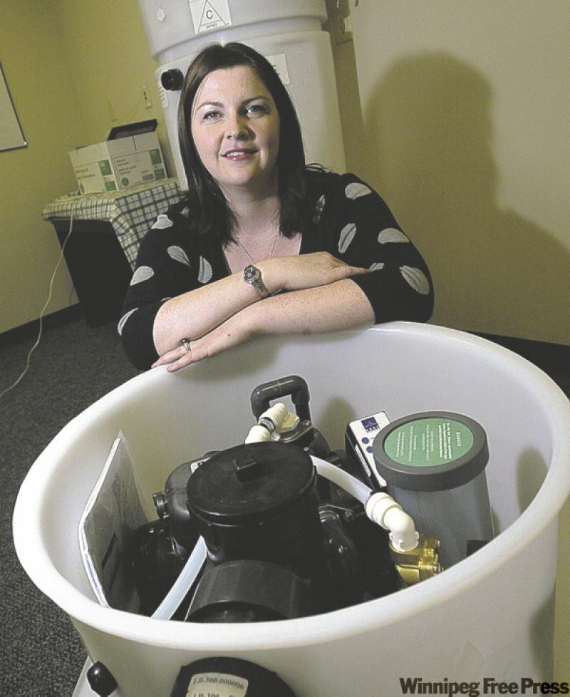 Teri Clegg with the exposed innards of a grey-water recycler for your home.