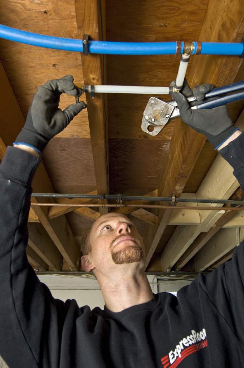 Plumbing expert installs new plastic pipes in a home's plumbing system.