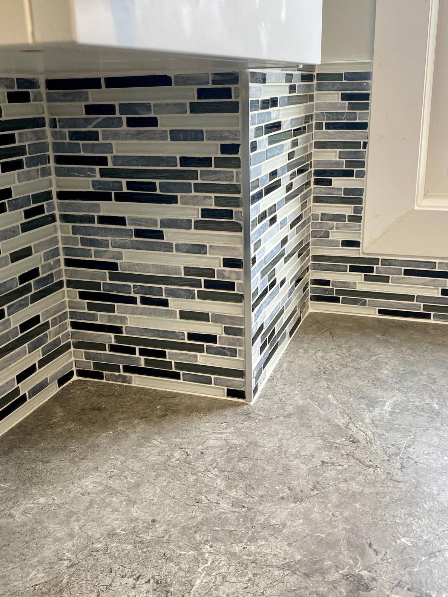  <p>The exposed 90-degree corner of the bump-out and top edge of the backsplash are fitted with stainless-steel tile edging.</p> 