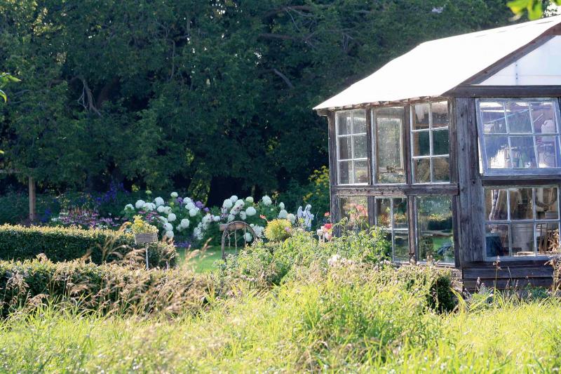 This rustic, weathered potting shed in Neepawa with recycled windows that look onto a herb garden is the perfect springtime refuge for a winter-weary gardener.