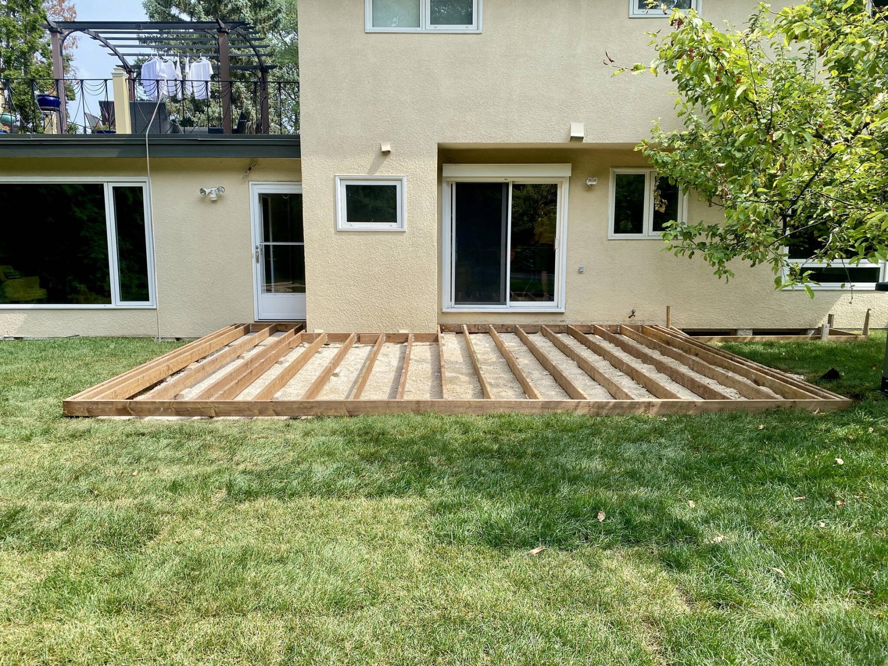  <p>Once the deck footprint was prepped with three-quarter down gravel, 2x6 joists are aligned at 16 inches on-centre atop small concrete pads below every joist.</p> 