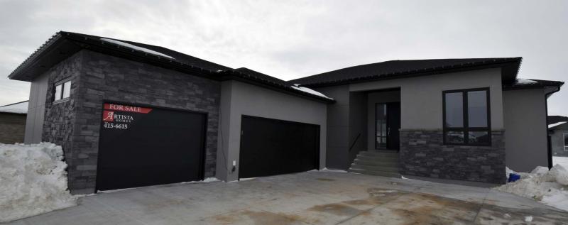 <p>Photos by Todd Lewys / Winnipeg Free Press</p><p>The home&rsquo;s exterior features a handsome combination of grey stone trim, beige acrylic stucco, dark brown garage doors and an espresso-stained front door set back beneath a covered entrance.</p>