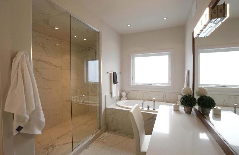 <p>The master bathroom features a glass-and-tile shower and an oval soaker tub. </p>