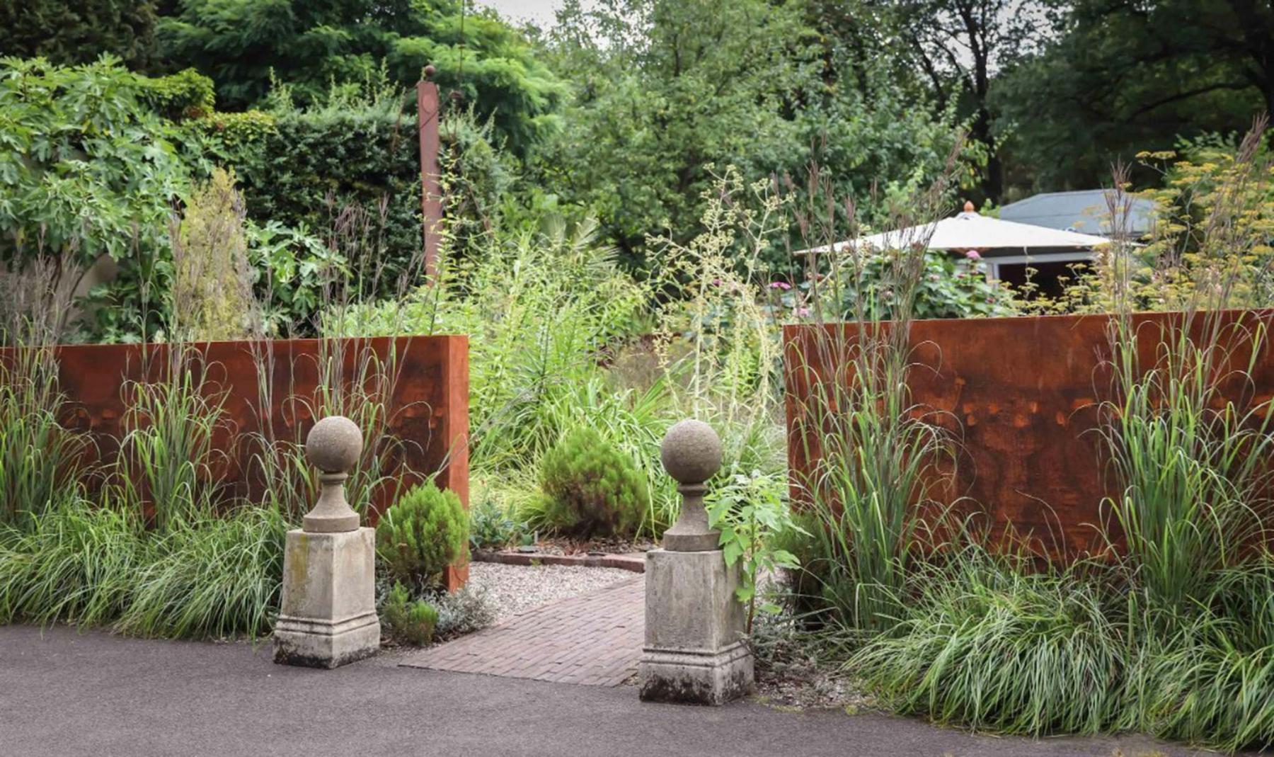 <p>Carex Tours photo</p><p>A weathering steel wall frames the entrance to German designer Peter Janke&rsquo;s herb garden.</p>