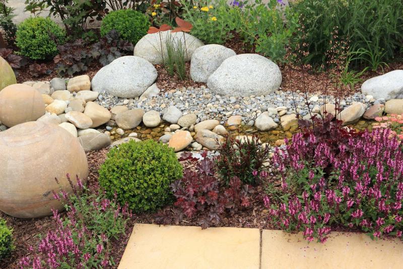 <p>iStock fotolinchen</p><p>As rainfall causes water to flow, a rock-swale creates a water channel, capturing the water so that it slowly percolates into the ground, slowing down the runoff process.</p>