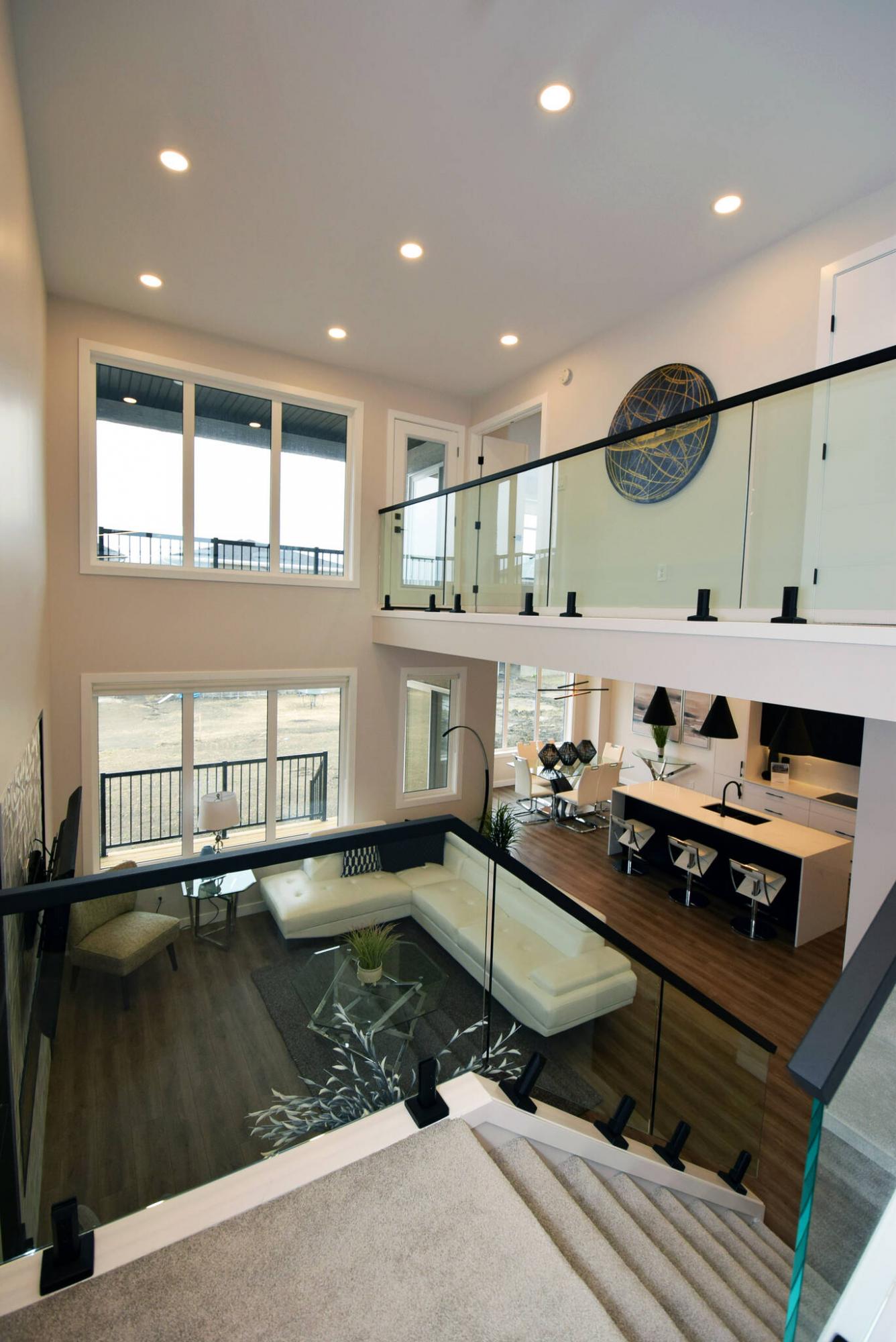 <p>Todd Lewys / Winnipeg Free Press</p><p>The view down to the main living area from the glass-bordered upper level staircase in this Prairie Pointe home is simply stunning.</p>