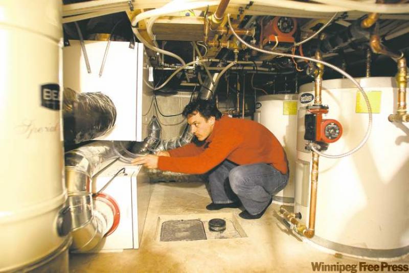 Christopher Straka of Vert Design, which designed Canada's first certified passive solar house, is seen in the crawlspace for heating units. The Ottawa house uses about one-tenth the energy that a conventional
Canadian house does.