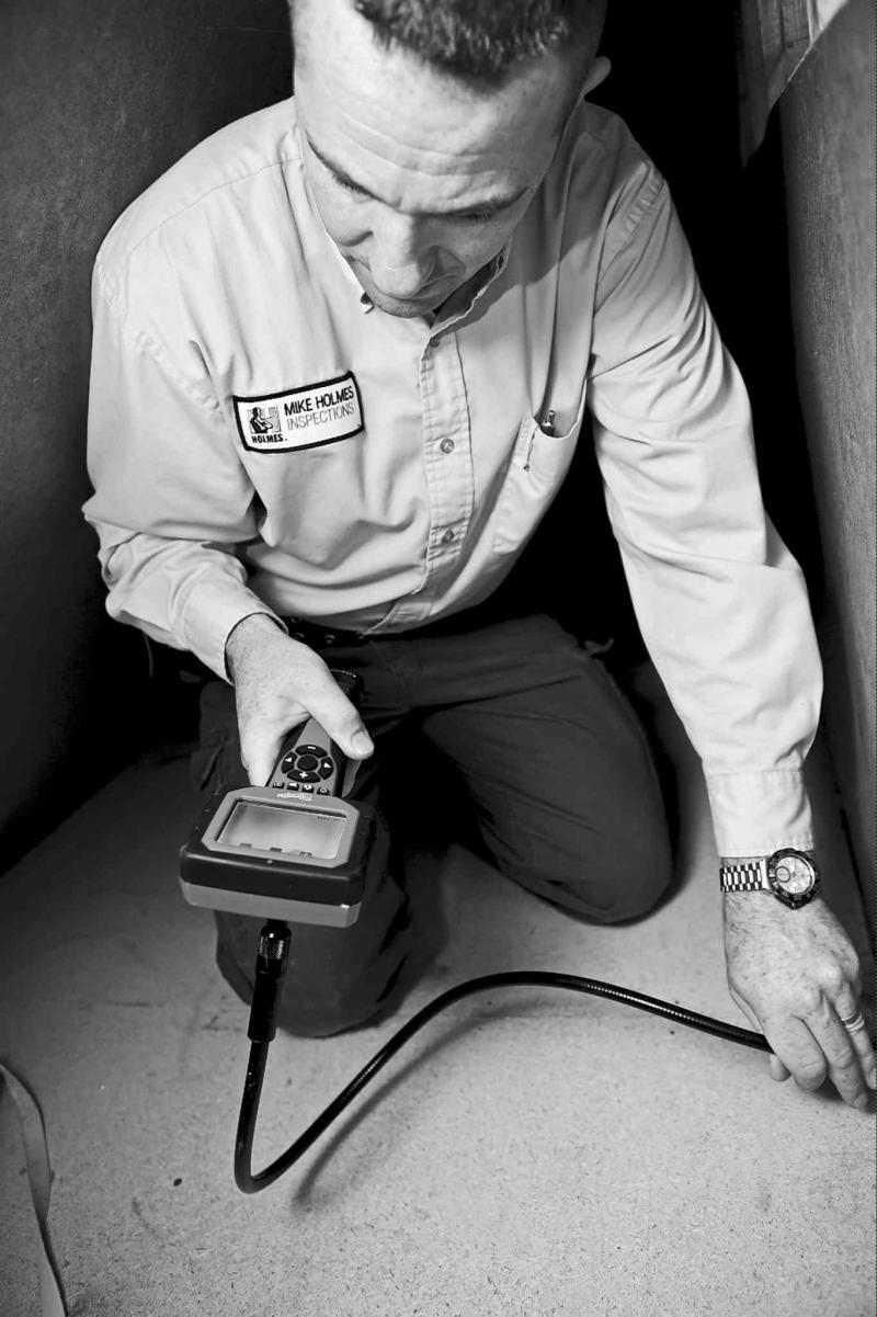 Inspecting the crawl space of a house with a digital inspection camera.