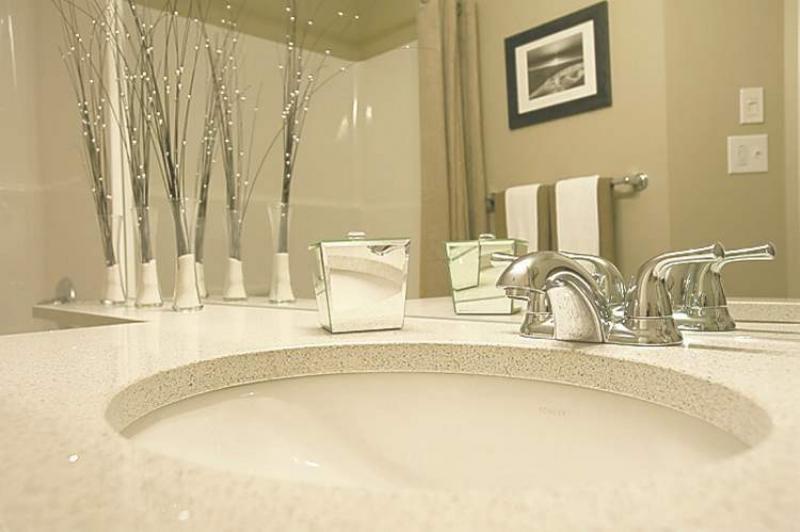 The ensuite includes a soaker tub, portobello vanity with quartz countertop and (tan) tile floor.