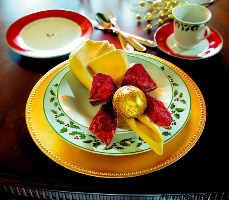 Place a gold charger under each place setting and dress up the napkins with bows, candles and spices.