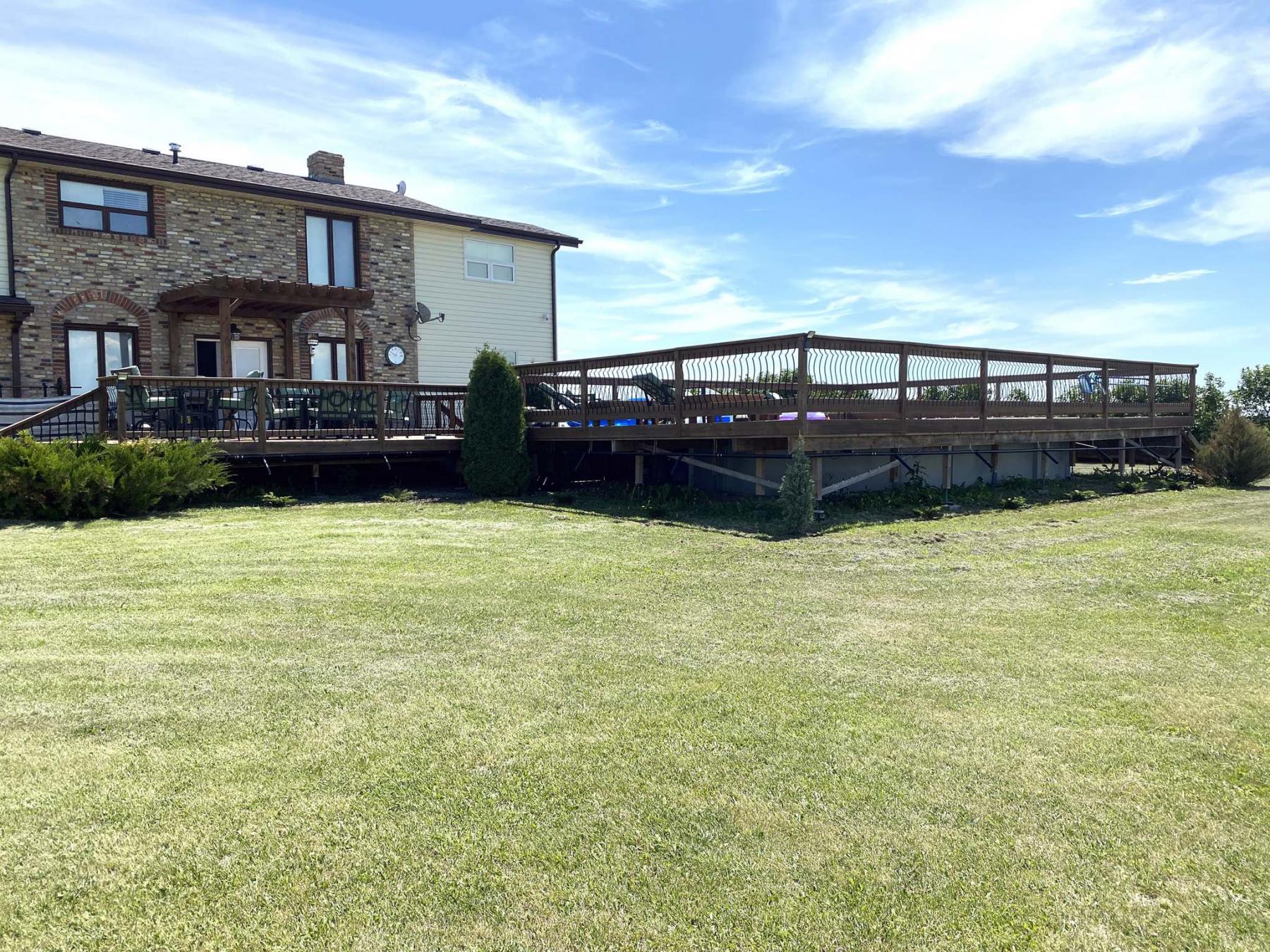 <p>The ABS main line attached to the underside of the rear deck is barely visible from the yard solves two issues: no more pooling of water and the evergreens receive ongoing watering.</p></p>