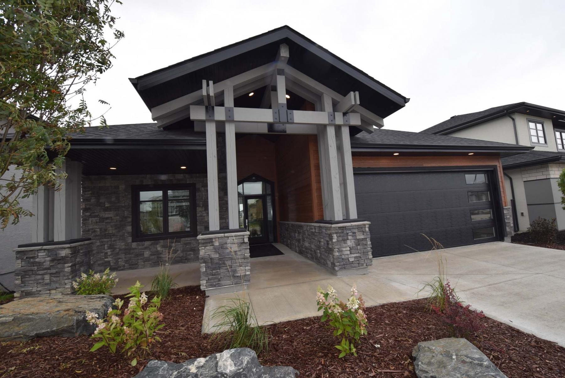 <p>TODD LEWYS / WINNIPEG FREE PRESS</p><p>The clean, linear design of 661 Bridge Lake Dr. starts with a classy, understated exterior. The entrance features a peaked roof with wooden pillars and beams and cultured stone trim.</p>