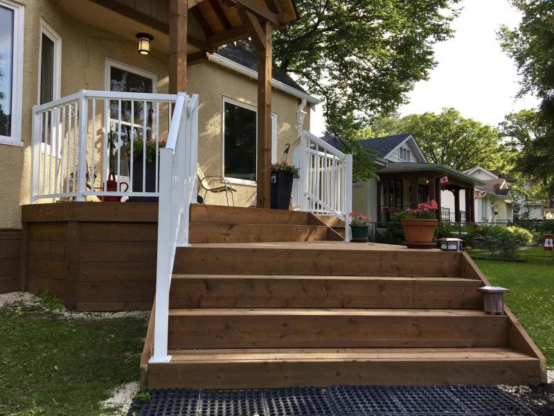 <p>Front facade of house from ground perspective, which showcases the new deck and railings.</p>
