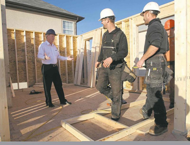 Mike Moore, president of the Manitoba Home Builders' Association, left, talks with local homebuilders.