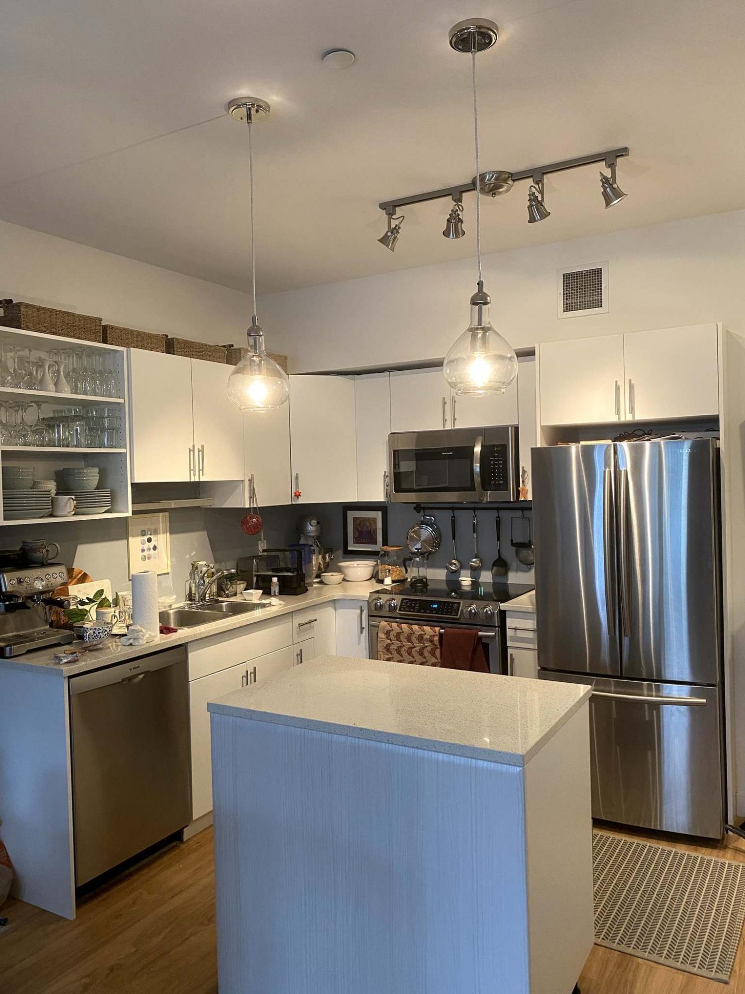 <p>Photos by Marc LaBossiere / Winnipeg Free Press</p><p>A decorative track light replaced an old kitchen fixture, while two fish-bowl pendants were introduced above the island.</p>