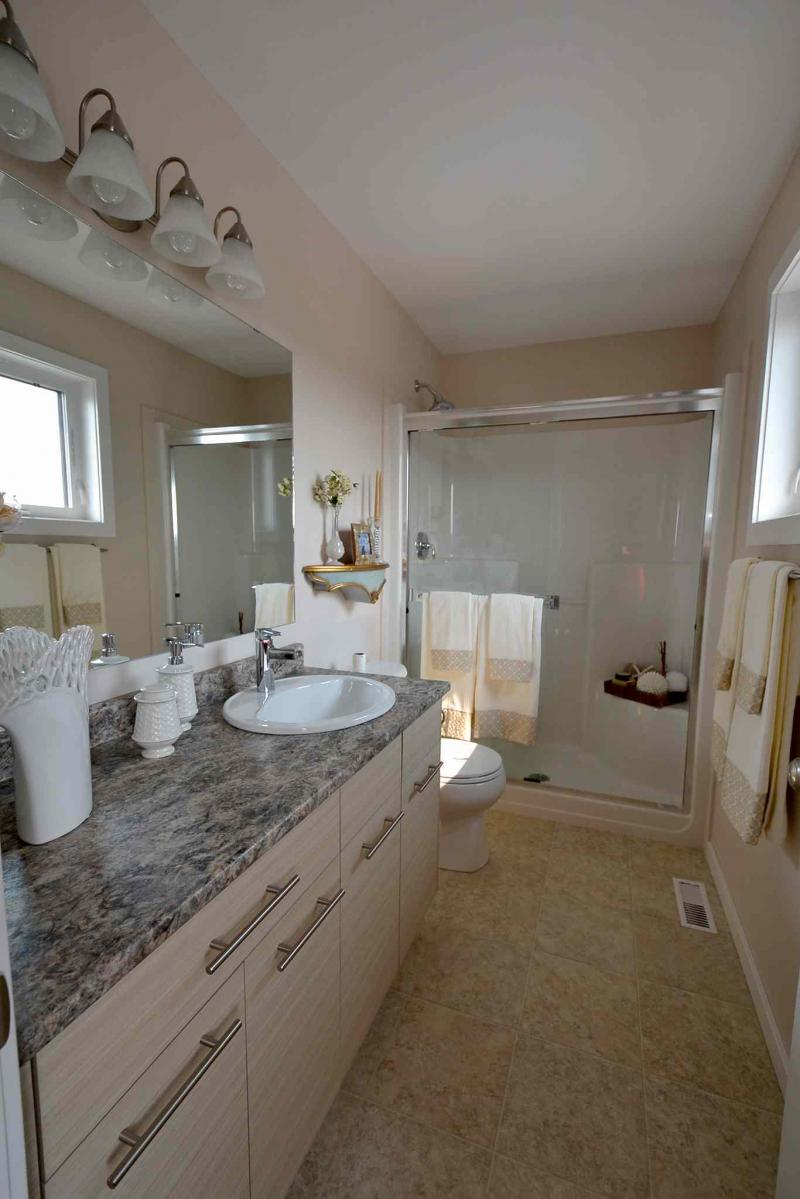 The ensuite is well-appointed with five-foot, low-step-over shower, thermofoil vanity and smart faux tile vinyl floor.