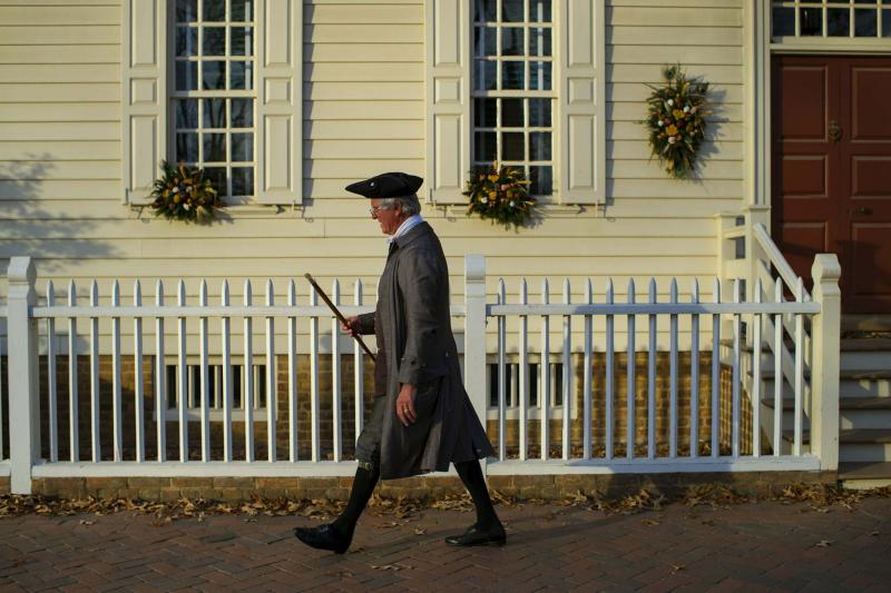 This is a holiday scene you might see in Colonial Williamsburg, Va., this month, as interpreter Dennis Montgomery walks past the Prentis House, which is decorated in swags made with natural materials. (Photos by John McDonnell / Washington Post)