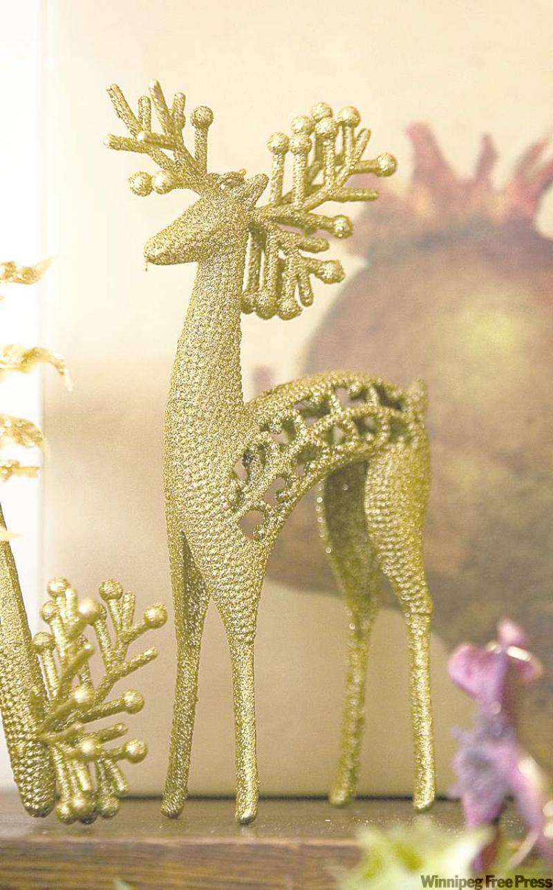 A golden reindeer is an elegant anchor on the edge of a fireplace mantel.