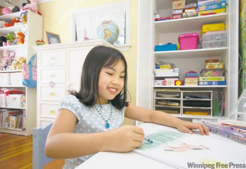 Emma Woo, 8, enjoys working at her art table.