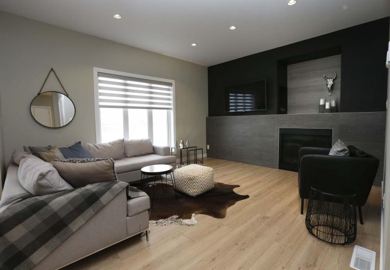 <p>WAYNE GLOWACKI / WINNIPEG FREE PRESS</p><p>The kitchen backs onto a spacious, yet intimate family room with medium brown oak-style luxury vinyl plank flooring and a grey tile entertainment unit with gas fireplace.</p></p>