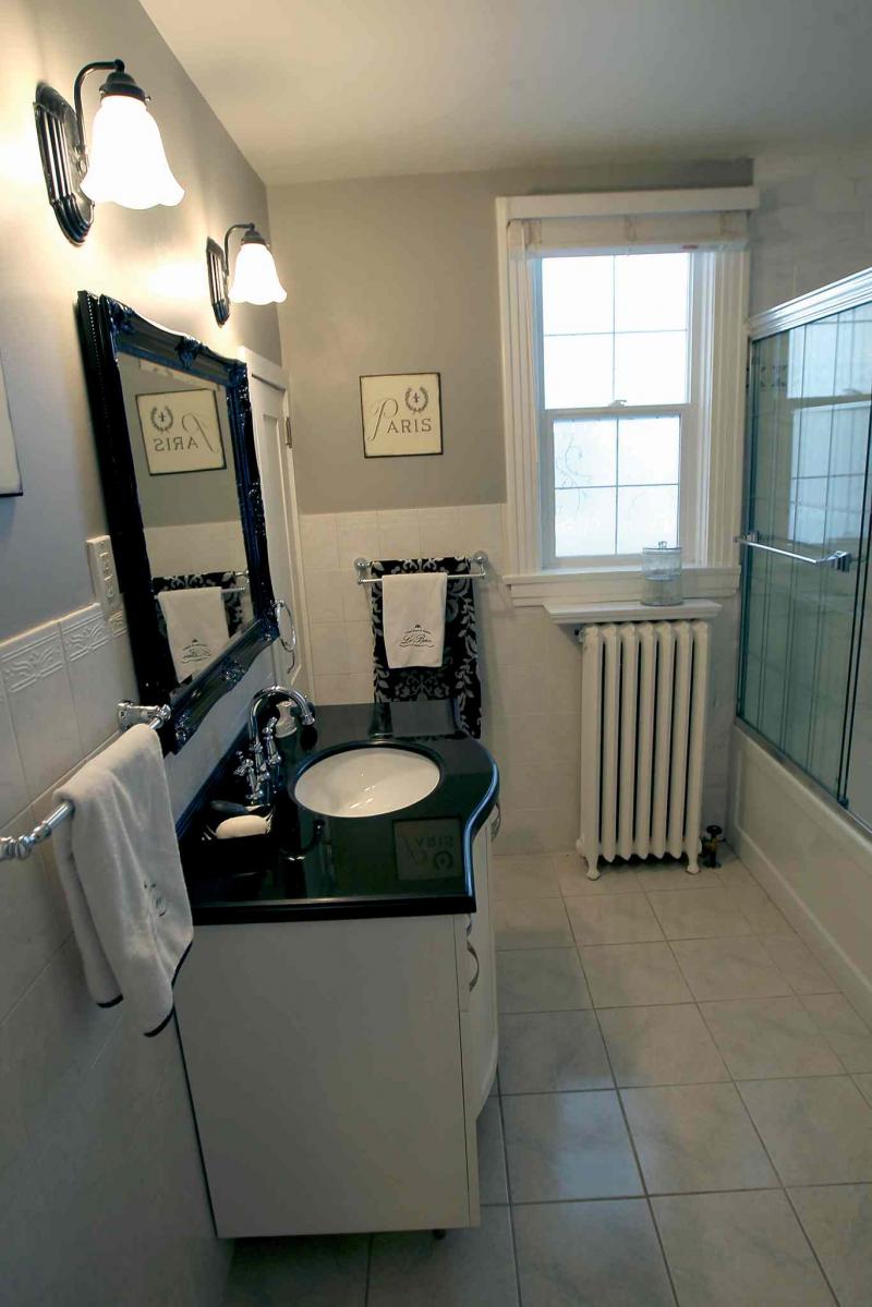 The second-floor bathroom features a soaker tub and contemporary vanity with black granite top.