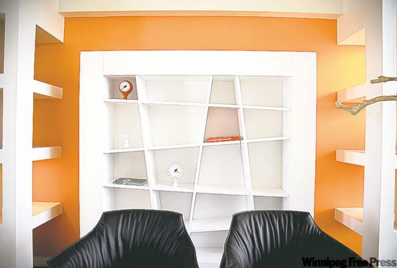 A white Ligne Roset bookcase provides a perfect contrast to the tangerine colour of the walls.