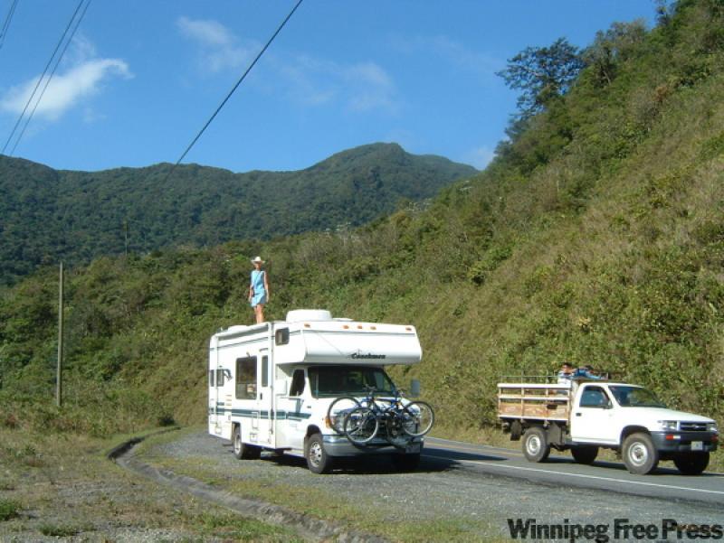 Harriet Halkyard poses on top of her  RV right on the Chiriqui Grande Road in  Panama. 