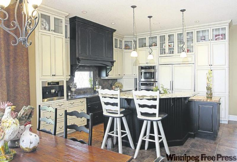 In the kitchen, maple wall cabinets have been antiqued in a cream glazed finish and set off by dark granite countertops.
