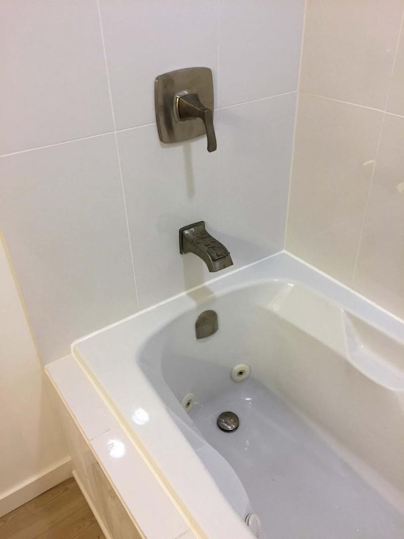 <p>The tub was sealed along the tile edges with white silicone.</p>