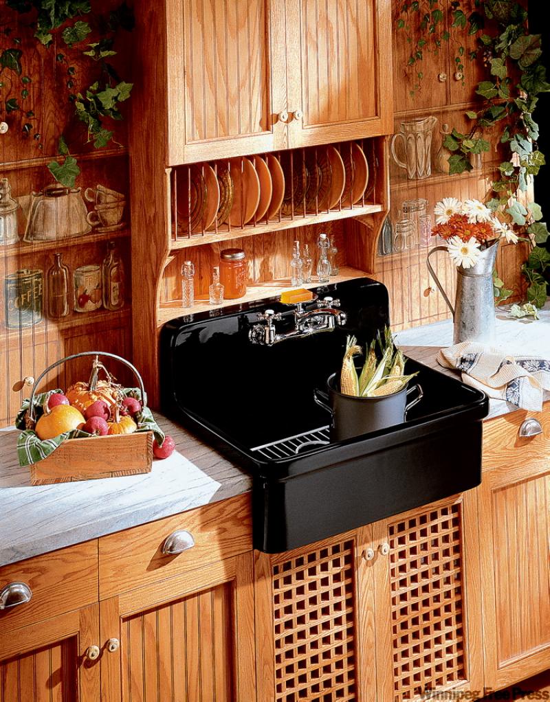The black Kohler apron sink evokes the charm of the past in a modern fixture. The country charm of the cabinets adds warmth and texture.