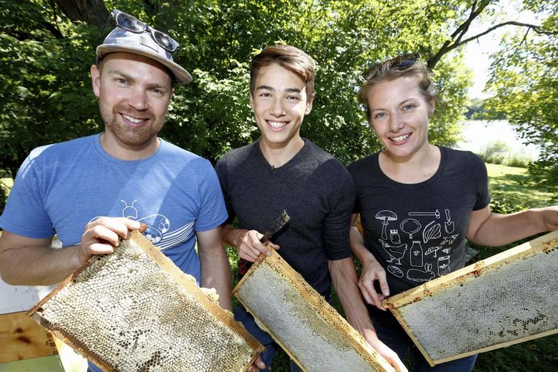 <p>JUSTIN SAMANSKI-LANGILLE / WINNIPEG FREE PRESS</p><p>Chris Kirouac (left), Lucas Smith and Lindsay Nikkel pose with honeycomb racks after removing them from their urban hives.</p>