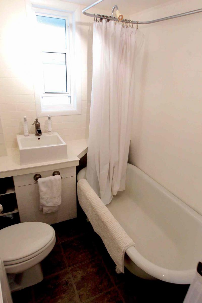 A classic clawfoot tub and raised, square ceramic sink are found in the main bath.
