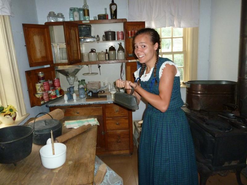 <p>Elisabeth, a summer employee at The Historical Museum of St. James / Assiniboia, with an antique iron.</p>
