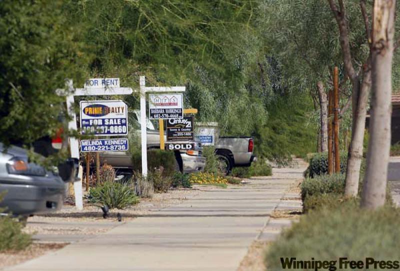 Real estate signs posted in front of houses in the Villages of Queen Creek subdivision in Queen Creek, Ariz., a community outside Phoenix. (Ross D. Franklin/Associated Press archives)
