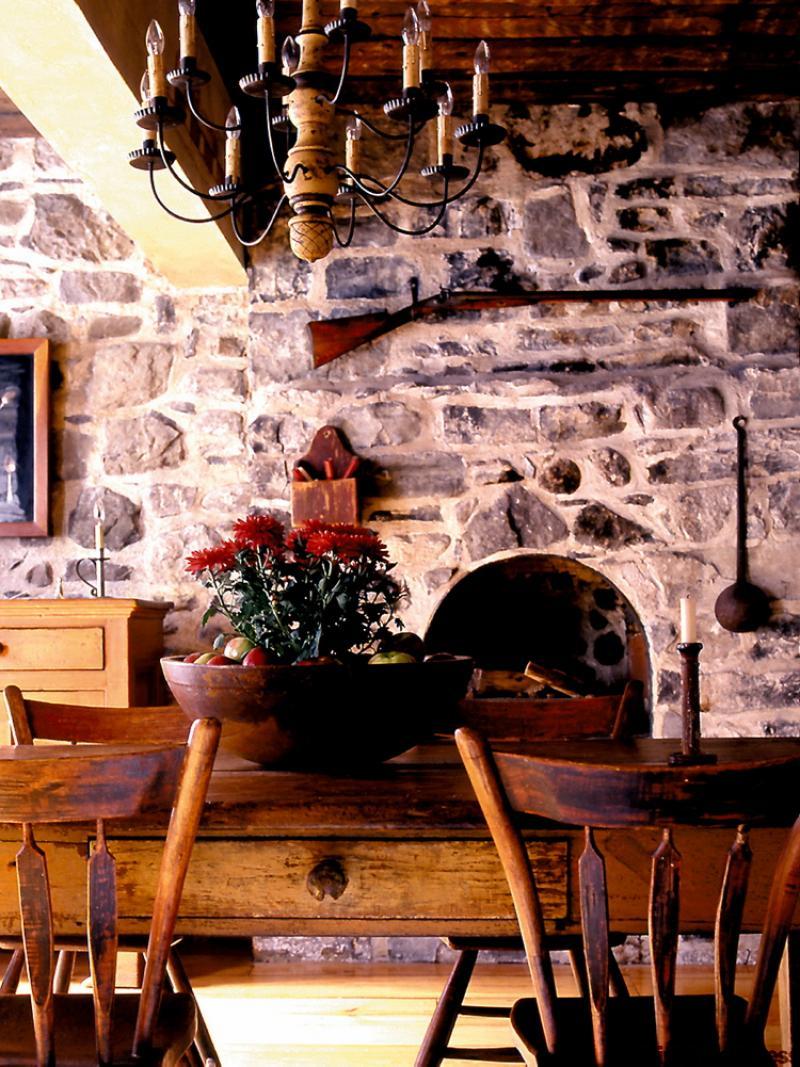 The dominant stone fireplace wall makes a suitable backdrop for exhibiting antique collectibles of country life.
