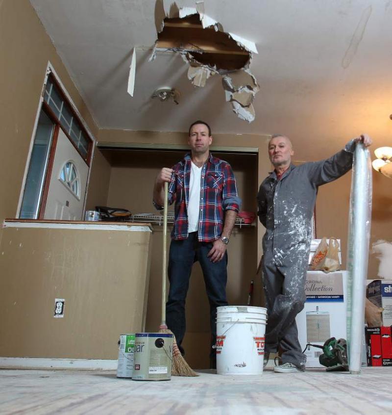 Jason Holt and Jym Genesta hold their reno toolsin the house they bought under foreclosure.