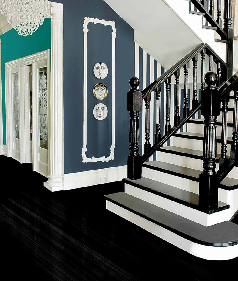 The ornate staircase is definitely dramatic, but notice the wide baseboards and decorative column flanking the doorway.