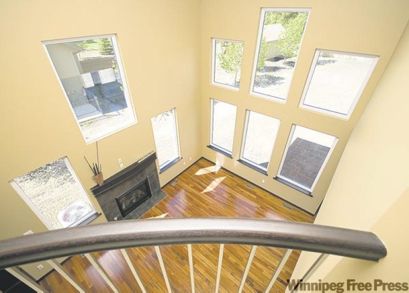 An extra-wide staircase to accomodate traffic, cappuccino-stained maple cabinets and granite counter tops in kitchen (below) and a large main bath are features of 16 Kuypers Cres.

