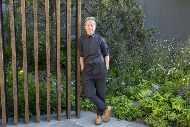 <p>MARIANNE MAJERUS</p><p>Landscape designer Charlotte Harris leans against the patinized copper verticals of the loggia she designed with woodland plantings on a rhythmic repeat framing the background.</p>