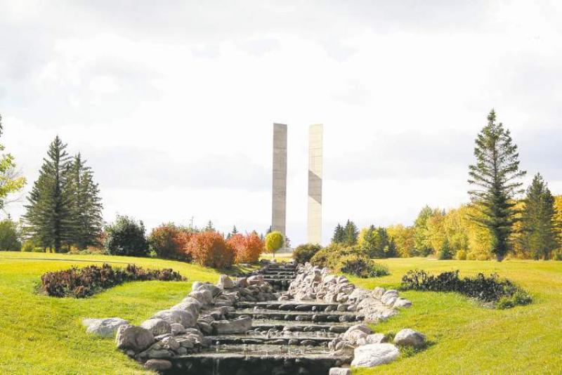A narrow, terraced channel of water flows through the centre of the formal garden at the 49th parallel. In the background stands the Peace Tower -- four concrete columns reaching 37 metres in height.