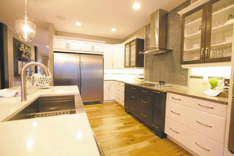 The kitchen features a nice combination of white and chocolate maple cabinets.